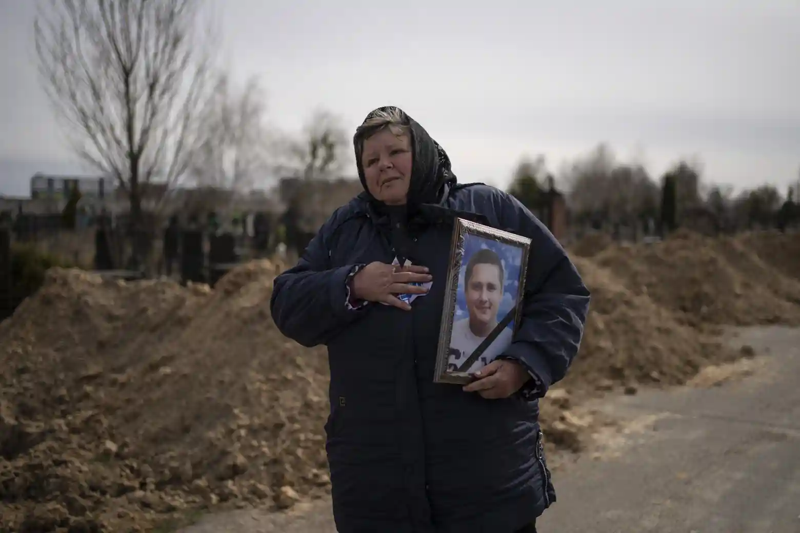 A woman carries the portrait of Dmytro Stefienko, 32, a civilian killed during the war in Bucha, in the outskirts of Kyiv , Defense Express