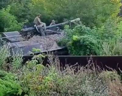 Ukrainian soldiers move to the designated firing position on top of their improvised howitzer, summer 2023