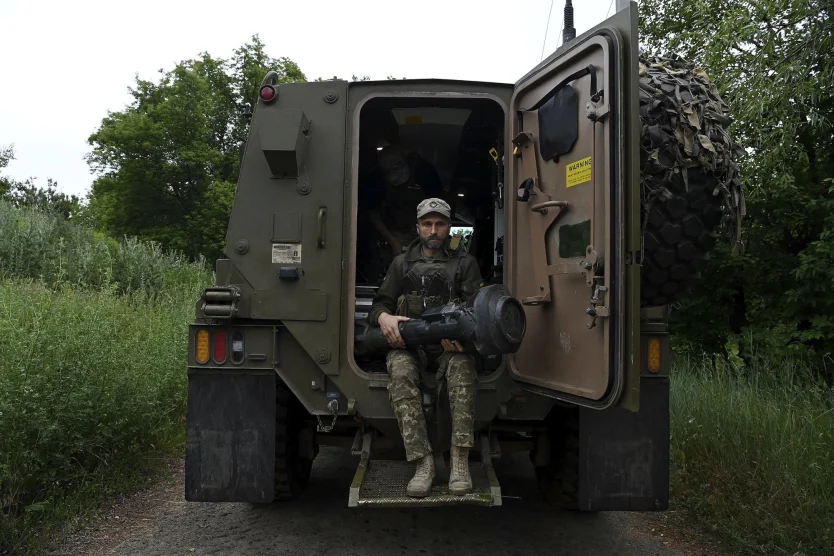 Ukrainian soldier sitting on the backrear exit from a Bushmaster