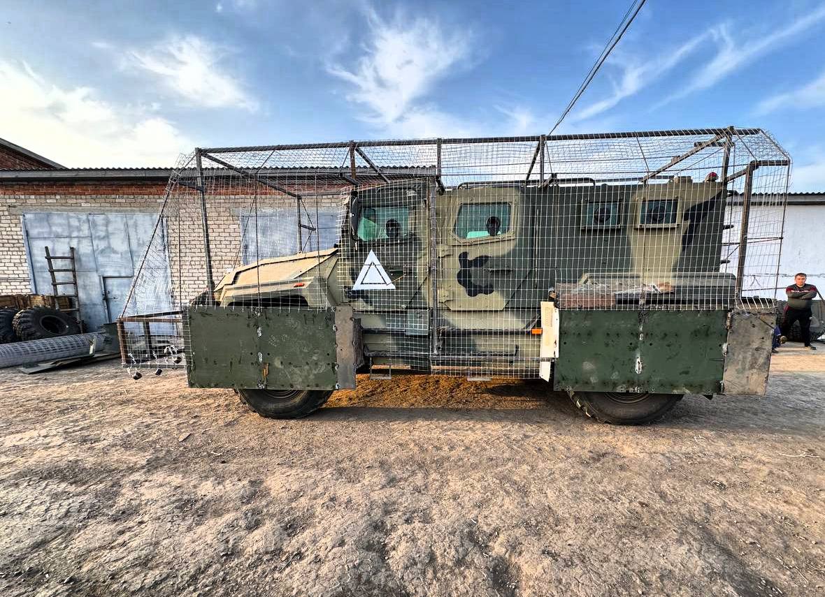 A russian AMN-590951 encaged in slat armor / Defense Express / Rare russian AMN-590951 Spartak Vehicle Destroyed by an FPV Drone Behind the Combat Lines
