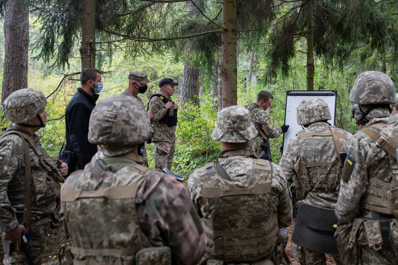 U.S Army Sgt. 1st Class Joshua Nickels observes Ukrainian Observer Controller Trainer Lt. Dmytro Suhai as his rotational training unit conducts an after action review following Military Operations on Urban Terrain at Combat Training Center-Yavoriv, Ukraine, Defense Express