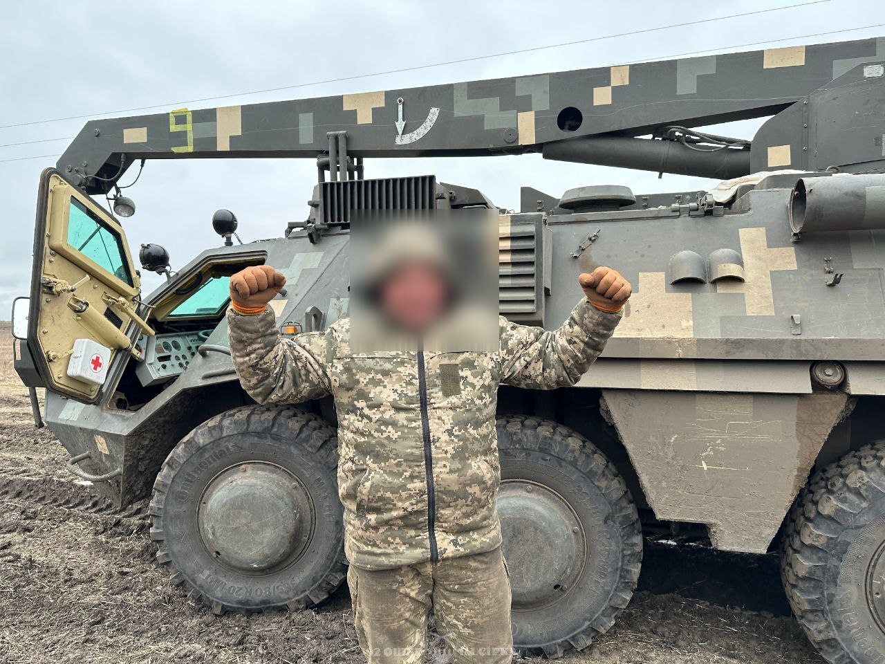 Soldier of the 92nd Brigade next to his BREM-4 armored auxiliary vehicle