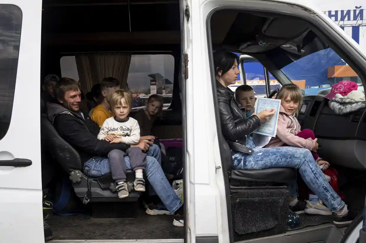 People with children wait after arriving from the Ukrainian city of Tokmak at a centre for displaced people in Zaporizhzhia, Ukraine, Defense Express