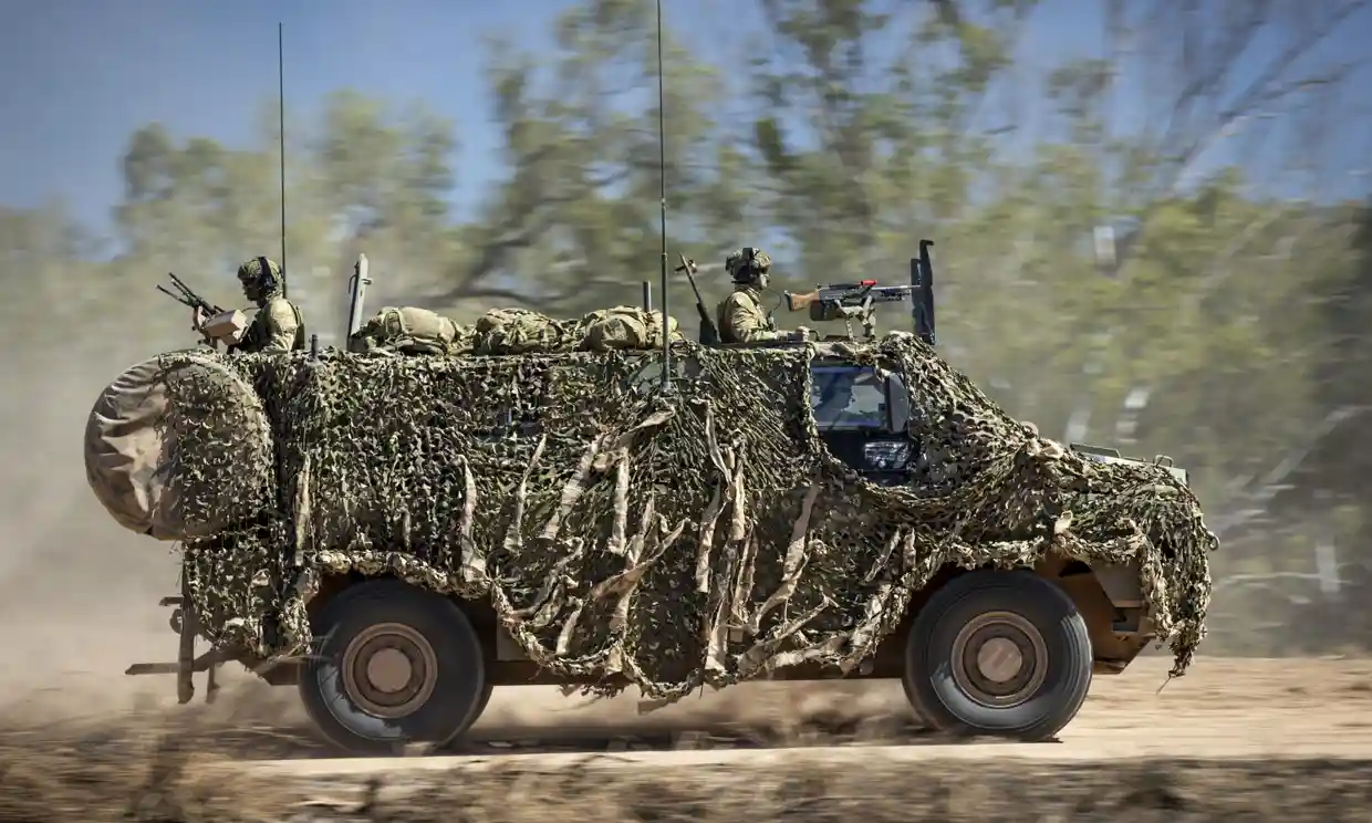 An Australian Army Bushmaster armoured vehicle moves off road during a training mission, Defense Express