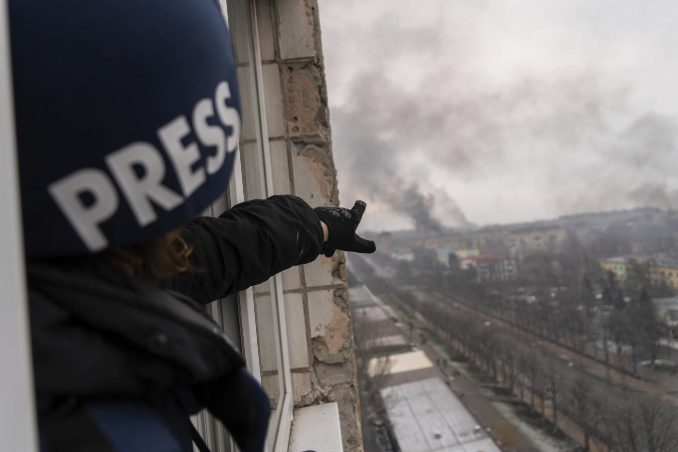 Why Russian Press-Tour for Foreign Media is a Provocation / Evgeniy Maloletka points at the smoke rising after an airstrike on a maternity hospital, in Mariupol, Ukraine