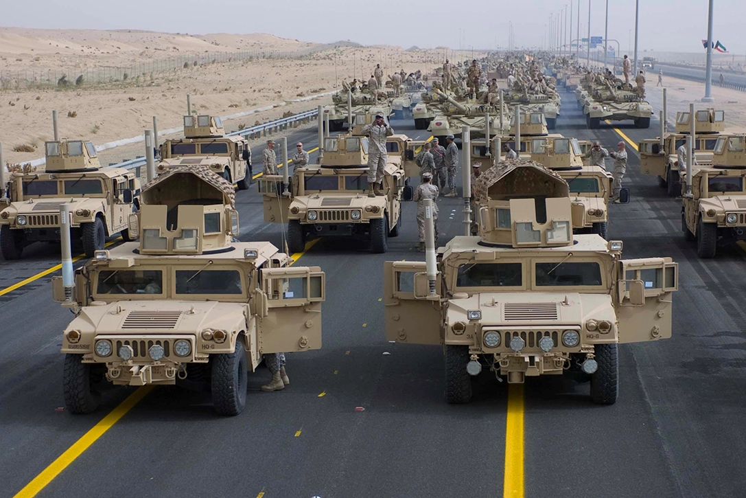 A formation of armored vehicles, manned by U.S. soldiers and Marines