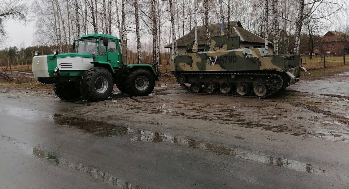 An immobilized russian BTR-MDM Rakushka infantry fighting vehicle towed by a Ukrainian tractor