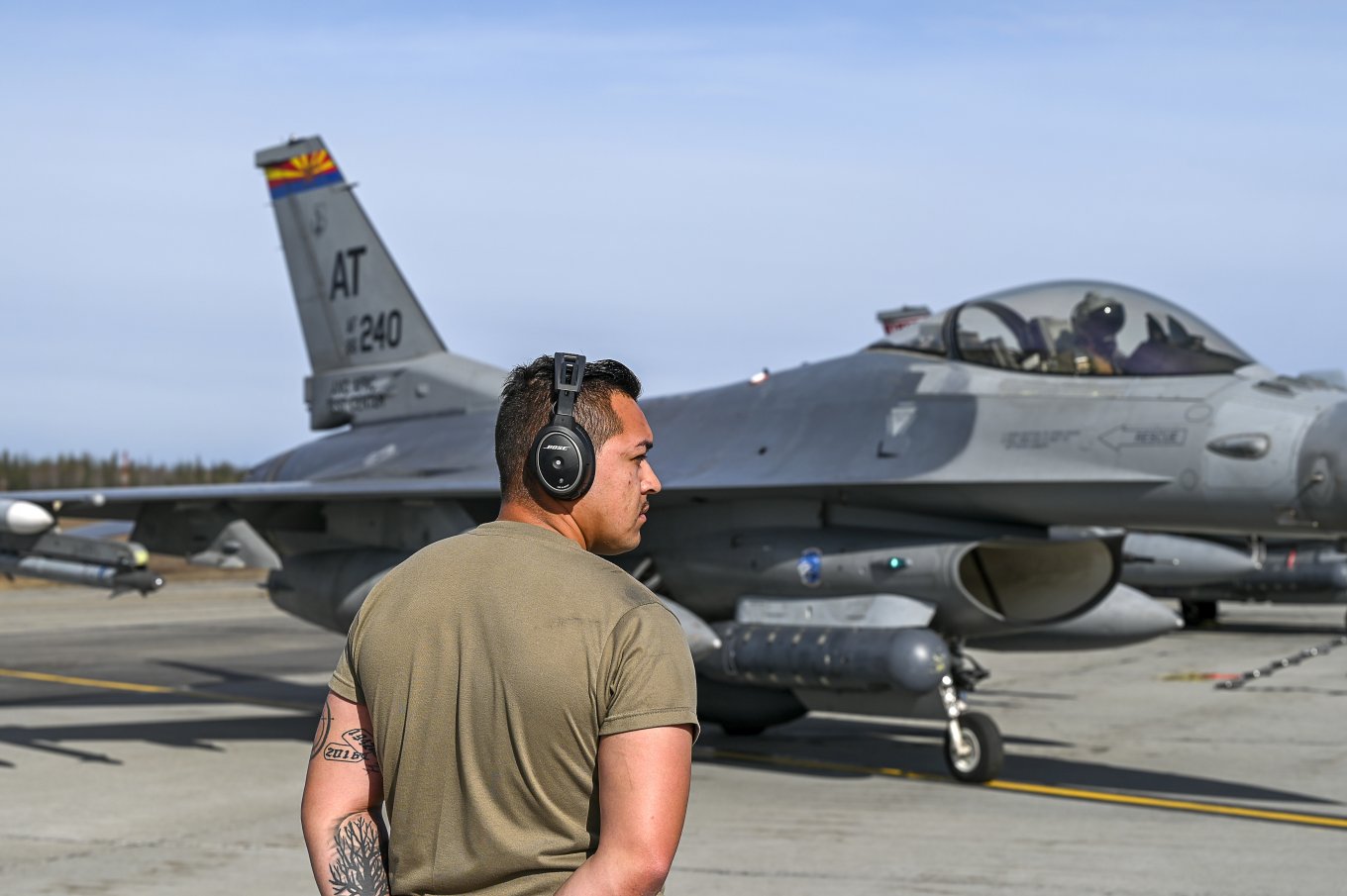 A crew chief prepares to marshal the launch of an F-16 Fighting Falcon aircraft, Alaska, May 11, Northern Edge 2023 Defense Express U.S. Tested Angry Kitten EW System on F-16 and A-10A Aircraft, Tanker Intelligent Gateway on KC-135R Tanker, and Upgraded MQ-9 Reaper UAV