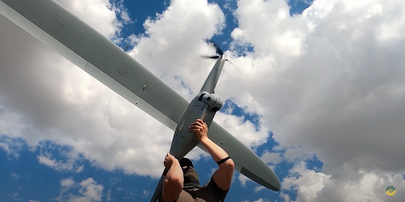 A SSU counterintelligence serviceman is launching a FlyEye drone / the FlyEye UAV can be launched manually
