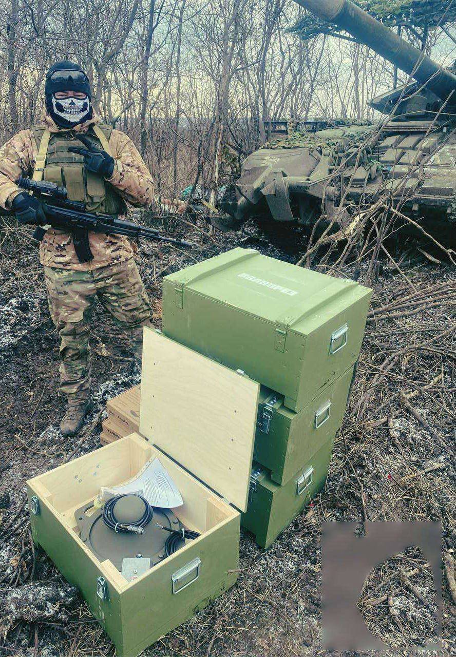 Ukrainian soldier next to his trophies, boxes with Volnerez EW systems
