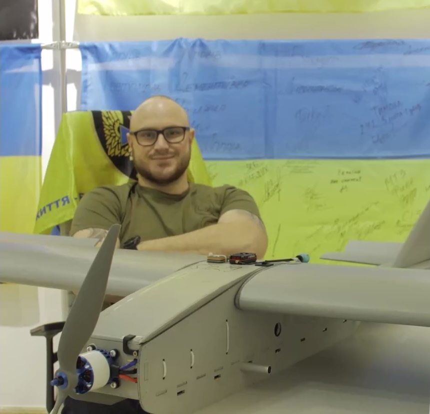 Ukrainian volunteer Orest Kryshtafovych next to a Darts winged FPV drone