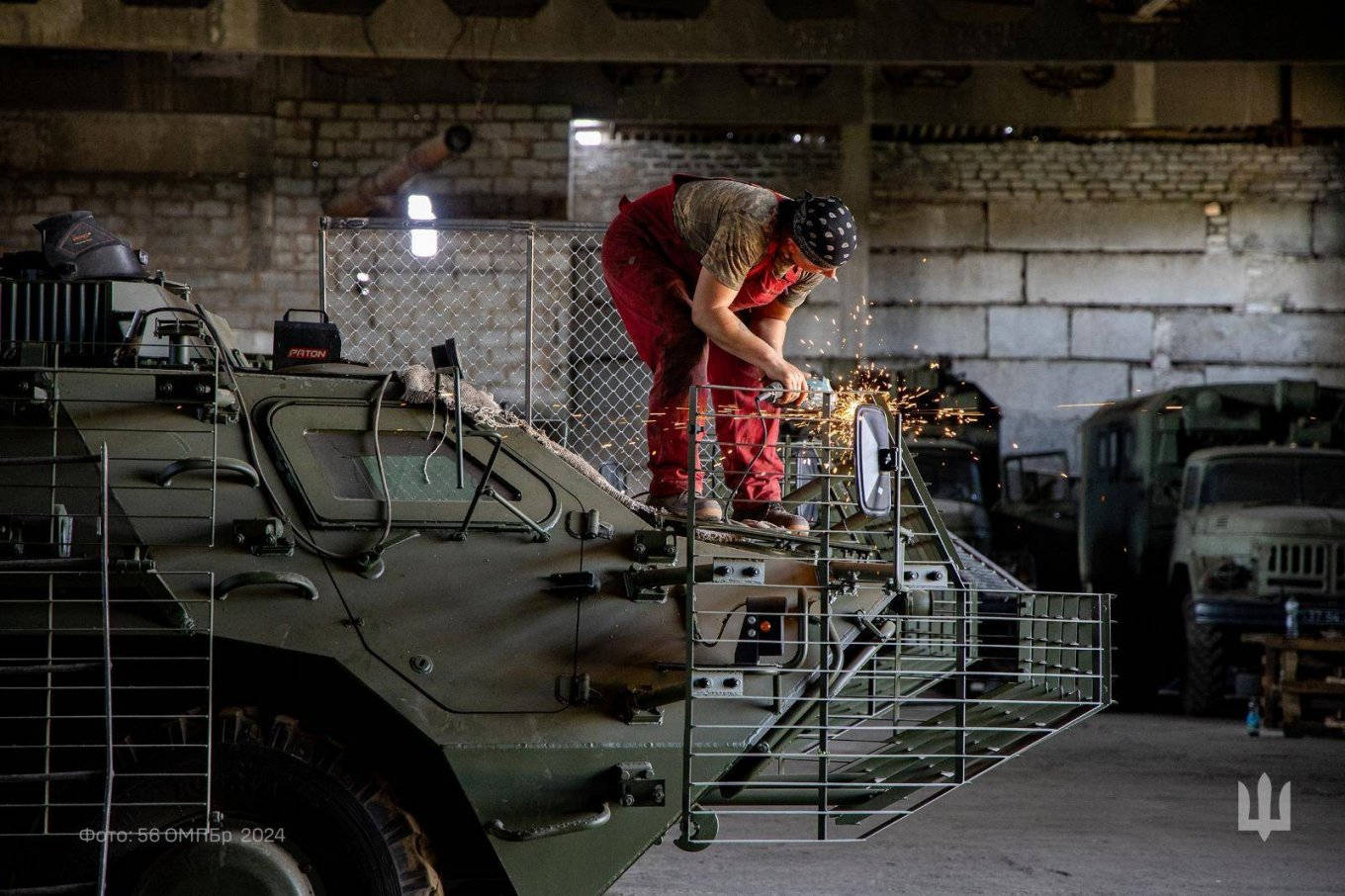 Illustrative photo: an engineer mounts slat armor on a BTR vehicle to protect it from FPV, bomber drone strikes and anti-tank weapons / Defense Express / Trial By Fire For Ukrainian Inguar APC: Insights From Manufactrer and Soldiers' Reviews