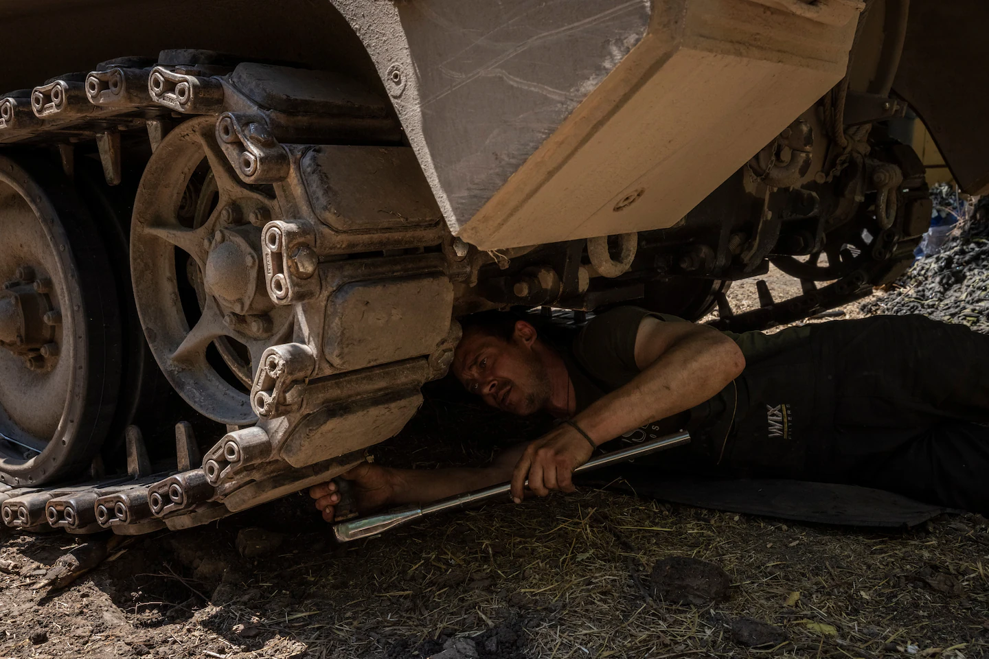 A Ukrainian mechanic at work on the damaged tracks of an M113. (Ed Ram for The Washington Post))