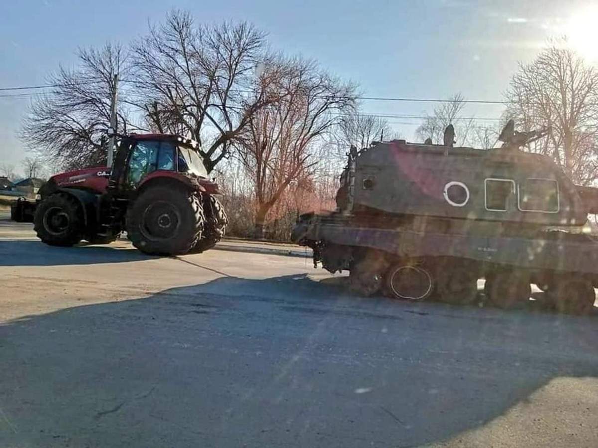 Defense Express/ Ukrainian tractor tows the harvest of russian equipment