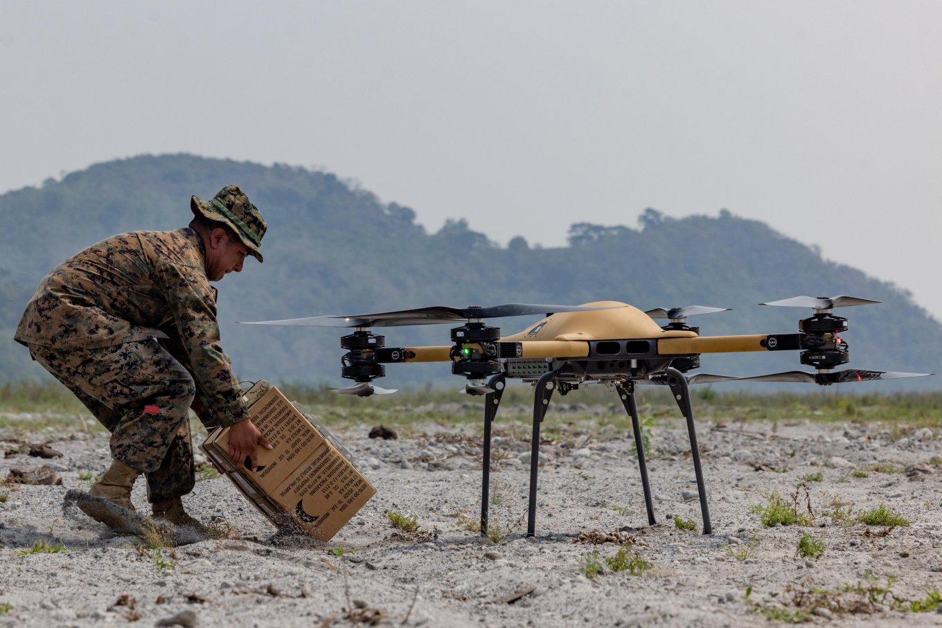 U.S. Marine Corps soldier attaches a box with supplies to a Malloy TRV-150 drone