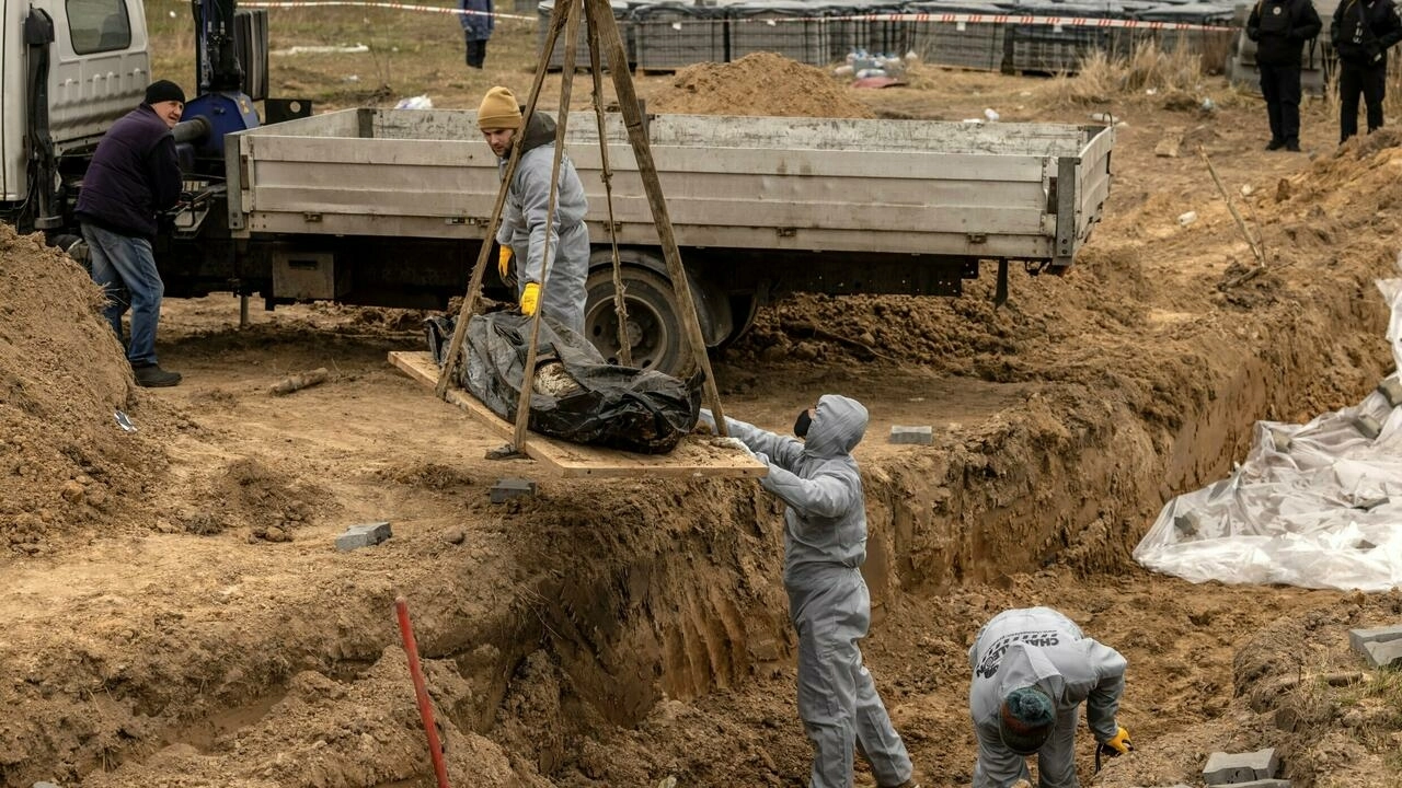 Workers exhume bodies at a site in Bucha, Ukraine where civilians killed during Russian occupation were buried, amid allegations of many war crimes by Russian fighters in the Kyiv suburb, Defense Express