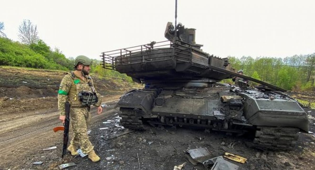 Ukrainian warrior near the Russian tank that was destroyed in the Kharkiv region, photo May 9, 2022, Reuters, Defense Express