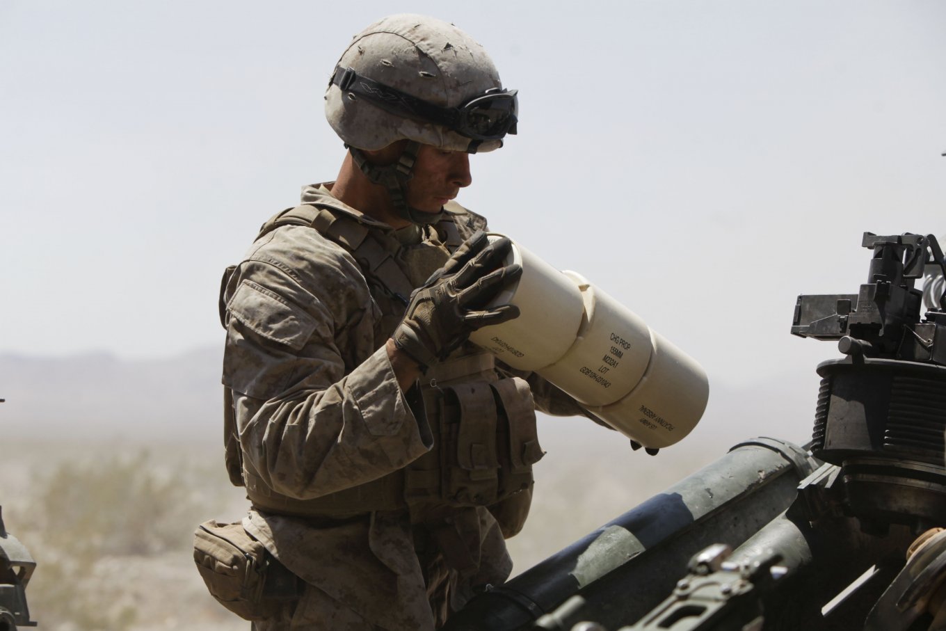 U.S. Marine loads charges into an M777 155mm howitzer during Exercise, U.S. is Falling Short on 155mm Artillery Shell Production: Current Output and 1 Million Goal Timeline