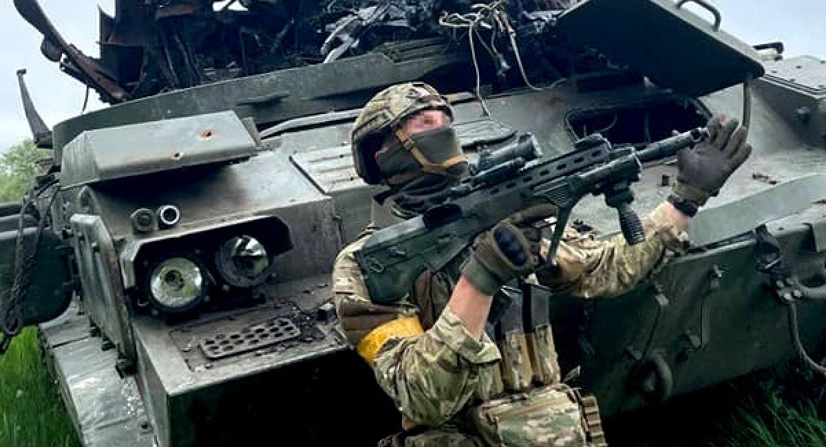 Ukraine's fighter posing in front of destroyed russia's vehicle / Photo credit: General Staff in Ukraine