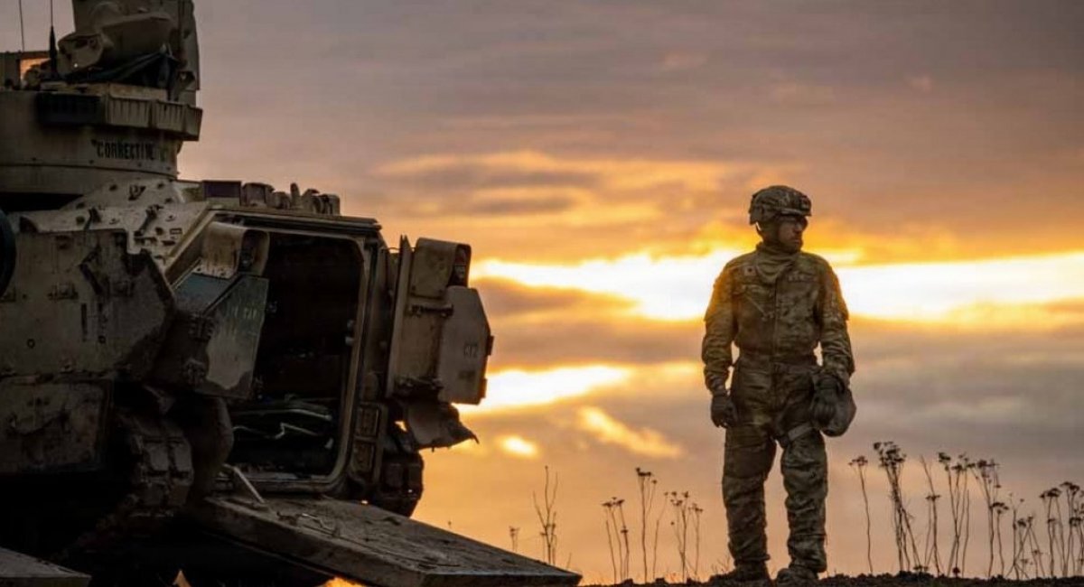 U.S. soldier against backdrop of armored vehicles at sunset / Open source photo 