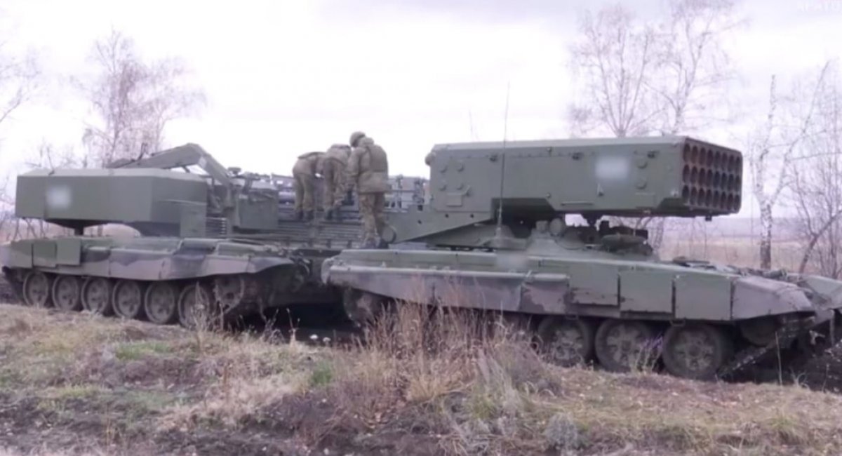 russian soldiers loading a TOS-1A, next to it we can see a TMZ-T reloader vehicle / Still image from the video