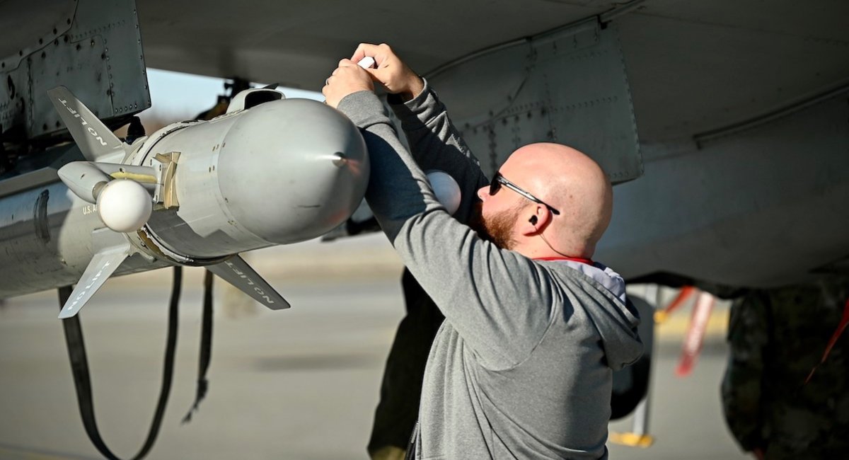 An electronic warfare engineer tightens a panel on the Angry Kitten combat pod under the wing of an F-16 Fighting Falcon aircraft, Alaska, May 5, Northern Edge 2023 / Photo credit: The Air National Guard
