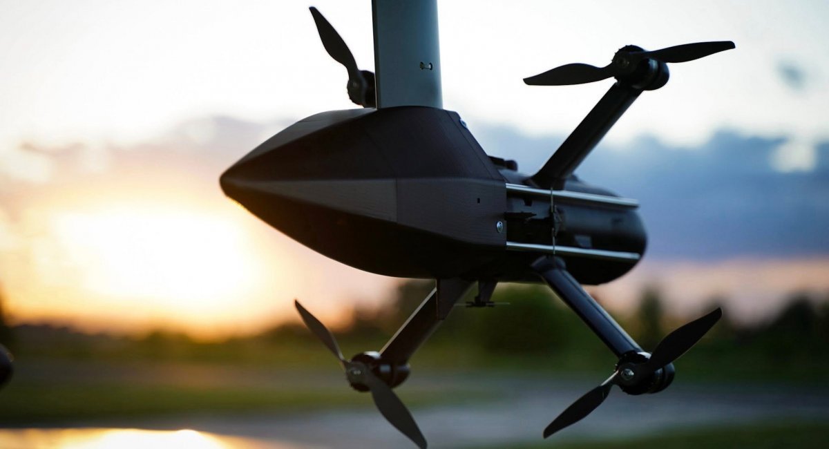 An interceptor drone mounted under the wing of an ultralight aircraft, likely an A-32